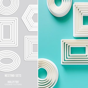 May include: A set of white nesting cookie cutters in various shapes, including circles, ovals, rectangles, and hexagons. The cutters are arranged on a gray and turquoise background. The text "NESTING SETS HOLLY FOX COOKIE CUTTERS" is printed below the cutters.
