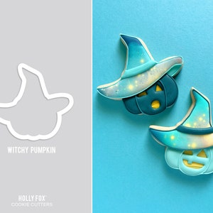 May include: Two blue and white witchy pumpkin cookie cutters with a starry sky design. The cookie cutters are on a light blue background. The text "Witchy Pumpkin" is printed below the cookie cutters.