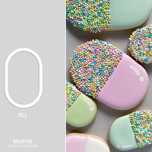 May include: A cookie cutter in the shape of a pill. The cutter is white and outlined in black. The word "PILL" is written below the cutter. The text "HOLLY FOX" and "COOKIE CUTTERS" is written below the word "PILL".