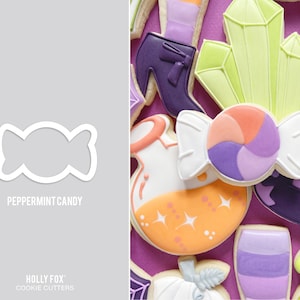 May include: A white cookie cutter shaped like a peppermint candy. The cookie cutter is on a gray background. The text "Peppermint Candy" is below the cookie cutter. The text "HOLLY FOX" and "COOKIE CUTTERS" is below the text "Peppermint Candy".
