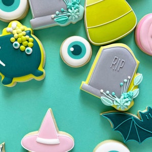 Puede incluir: Una colecci&oacute;n de galletas de az&uacute;car con tem&aacute;tica de Halloween decoradas con varios dise&ntilde;os, incluyendo fantasmas, murci&eacute;lagos, ojos, ma&iacute;z dulce y l&aacute;pidas con la palabra "RIP" en ellas.
