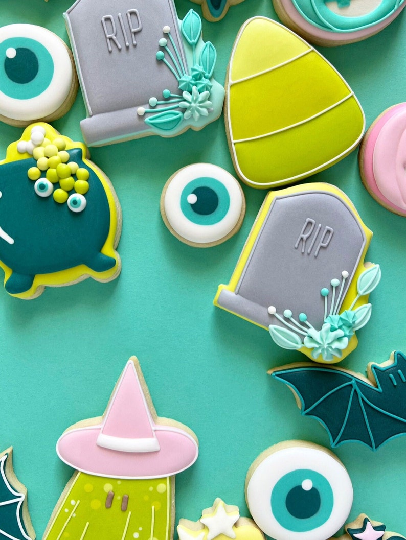 Puede incluir: Una colecci&oacute;n de galletas de az&uacute;car con tem&aacute;tica de Halloween decoradas con varios dise&ntilde;os, incluyendo fantasmas, murci&eacute;lagos, ojos, ma&iacute;z dulce y l&aacute;pidas con la palabra "RIP" en ellas.