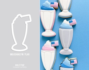 May include: A collection of decorated milkshake cookies with an American flag on top. The cookies are in the shape of a milkshake glass and are decorated with pink, blue, and white frosting. The background is a solid blue.
