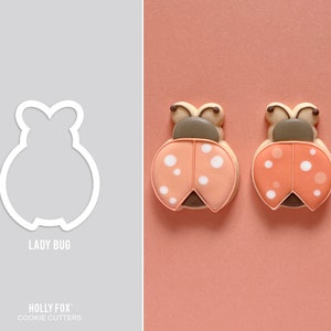 May include: Three pink and white ladybug cookie cutters with a white outline. The cookie cutters are on a pink background. The text "Lady Bug" is below the cookie cutters. The text "HOLLY FOX" and "COOKIE CUTTERS" is at the bottom of the image.