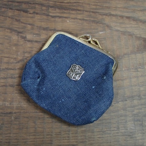 May include: A small blue denim coin purse with a metal clasp and a silver metal emblem.