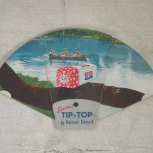 May include: A vintage advertisement for Tip-Top bread featuring a white loaf with red stars and the slogan "Enriched Tip-Top is Better Bread". The image shows a lake scene with a boat and three people rowing.