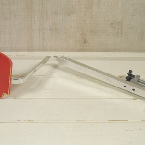 May include: A silver metal sign holder with a red sign that says "The Brandy of Napoleon COURVOISIER".