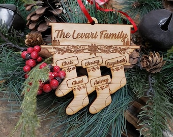 May include: A wooden Christmas ornament with the text "The Levari Family" and five stockings with names: Chris, Christy, Elizabeth, Chad, and Aubrey.