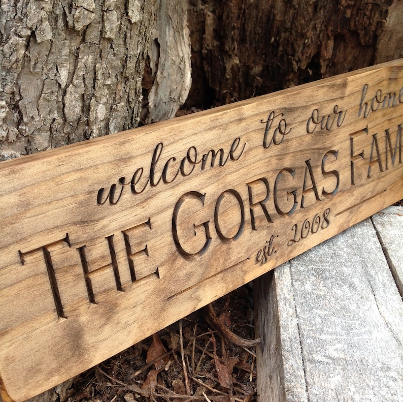 May include: A wooden sign with the text "Welcome to our home, The Gorgas Family est. 2008" carved into it.