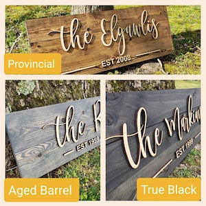 May include: Three wooden signs with different wood stains. The signs are all the same size and shape. The top sign is stained a dark brown color and says "the Elguulas EST 2008". The middle sign is stained a light gray color and says "the R EST 1959". The bottom sign is stained a dark black color and says "the Markin EST 1999".