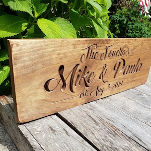 May include: A wooden sign with the text "The Fonecha's Mike & Paula est. c Aug. 3, 2019" carved into it.