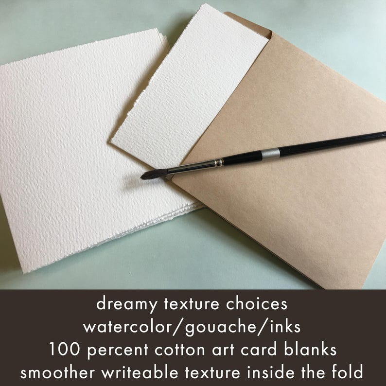 May include: A stack of white art card blanks with a textured surface, a paintbrush, and a brown envelope. The text on the image reads: "dreamy texture choices, watercolor/gouache/inks, 100 percent cotton art card blanks, smoother writeable texture inside the fold."