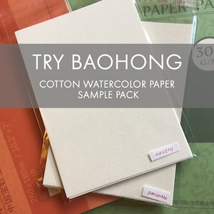 May include: A sample pack of cotton watercolor paper. The text "TRY BAOHONG" and "COTTON WATERCOLOR PAPER SAMPLE PACK" are displayed on the image. The paper is a light cream color, with the word "ACADEMY" and "BAOHONG" on small labels.