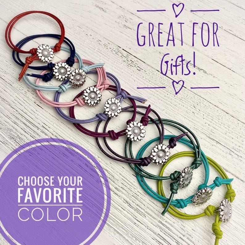 May include: A collection of colorful bracelets with daisy-shaped silver accents. The bracelets are in various colors, including red, blue, pink, purple, green, and yellow. Text in the image reads "GREAT FOR Gifts!" and "CHOOSE YOUR FAVORITE COLOR."