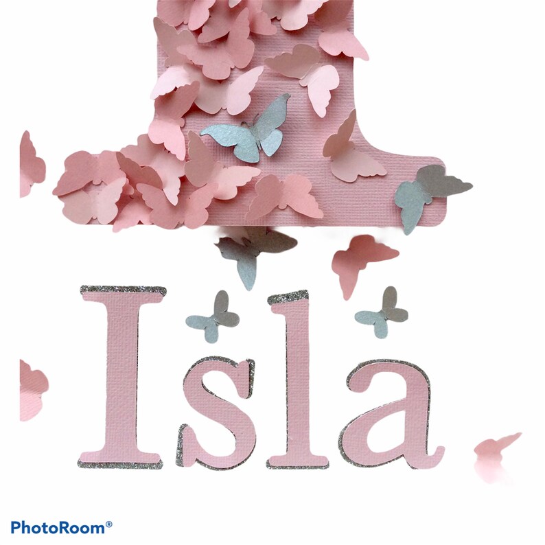 May include: Pink and silver glitter one with butterflies, the name Isla is spelled out below.