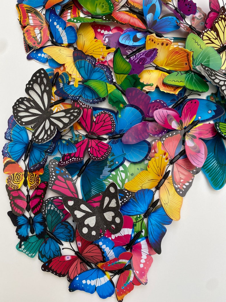 May include: A collection of colorful butterfly decorations with various patterns and designs. The butterflies are made of a lightweight material and have a wire attached to the back for easy hanging.