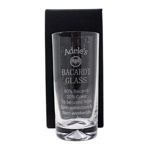 Könnte beinhalten: Ein klares Glas mit einem gravierten Design, auf dem "Adele's BACARDI GLASS 80% Bacardi 20% Coke To be used from 5pm weekdays & 9am weekends" steht. Das Glas befindet sich in einer schwarzen Box.