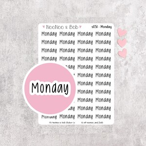 May include: A sticker sheet featuring multiple rows of the word Monday printed in a black sans-serif font. A large circular pink sticker with the word Monday in white is layered over the sheet. Three small pink heart stickers are placed to the right.