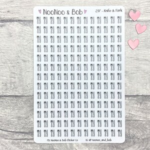 May include: A sheet of clear sticker paper with 100 black and white knife and fork icons. The sheet is labeled "NooNoo & Bob" and "217 - Knife & Fork".