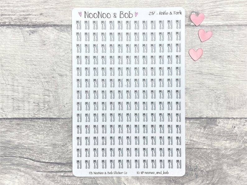 May include: A sheet of clear sticker paper with 100 black and white knife and fork icons. The sheet is labeled "NooNoo & Bob" and "217 - Knife & Fork".