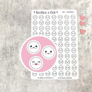Könnte beinhalten: Ein Stickerbogen mit Emoji-Gesichtern in Schwarz und Weiß mit rosa Akzenten. Der Bogen enthält drei kleine herzförmige rosa Aufkleber. Der Text "NooNoo & Bob" und "415 - Emotions" ist sichtbar.