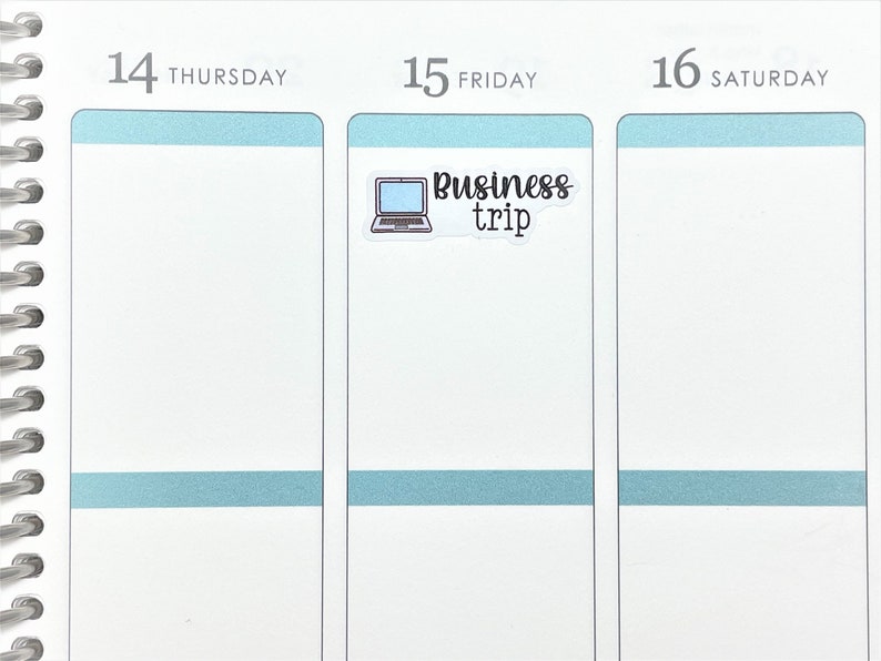 May include: A white planner page with a blue sticker that says "Business trip" with a laptop icon.
