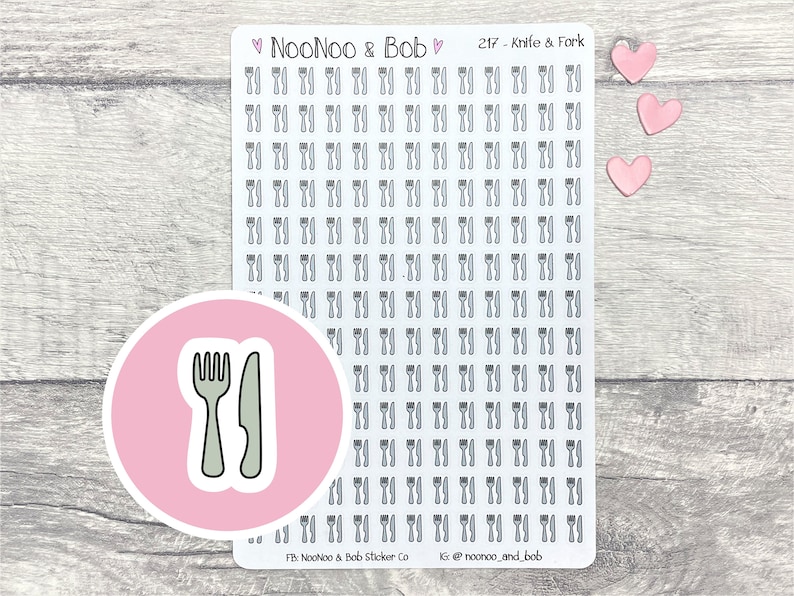 May include: A sheet of stickers featuring a repeated design of a knife and fork. The stickers are gray and white and are arranged in a grid pattern. The sheet is on a wooden surface. The text "NooNoo & Bob" and "217 - Knife & Fork" is printed on the sheet.