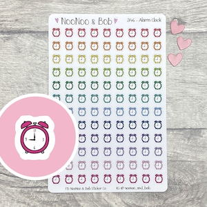 May include: A sheet of 346 colorful alarm clock stickers. The stickers are arranged in rows and columns on a white sheet. The sheet is on a wooden surface. The stickers are all the same size and shape, and they are all different colors. The alarm clocks are all black and white, and they all have the same design. The stickers are perfect for adding a touch of fun to your planner or journal.
