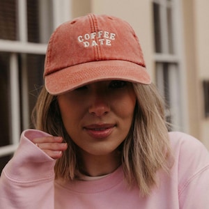 May include: A red baseball cap with the text "COFFEE DATE" embroidered in white.