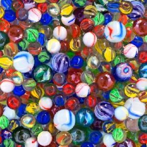 Puede incluir: Una colección de canicas de vidrio de varios tamaños y colores, incluyendo patrones transparentes, opacos y arremolinados en rojo, azul, verde, amarillo, blanco y morado, densamente agrupadas en una vista desde arriba.