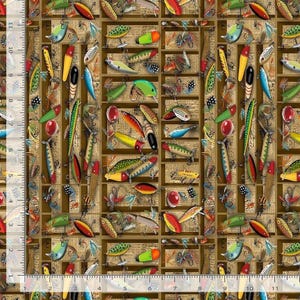 May include: A fabric print featuring a repeating pattern of colorful fishing lures and hooks arranged over a background of vintage newspaper text and brown vertical stripes, with a white ruler showing 11 inches along the left edge.