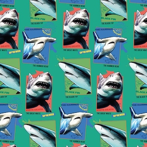 Op de afbeelding: Een groenblauwe stof met een herhalend patroon van verschillende haaiensoorten, waaronder hamerhaaien en witte haaien. Elke haai is ingelijst in een rechthoekig kader met tekstlabels zoals The Hammer Head, Black Fin en Shark Week.