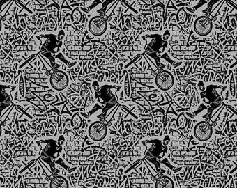 May include: A repeating pattern on a gray background featuring black silhouettes of individuals performing stunts on BMX bicycles. The design includes stylized graffiti-style text and brick wall textures integrated into the background.
