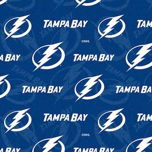 May include: A blue fabric pattern featuring the white Tampa Bay Lightning logo and the text Tampa Bay repeated across the surface. The design includes a subtle, distressed circular graphic behind the logo and the small NHL copyright symbol.