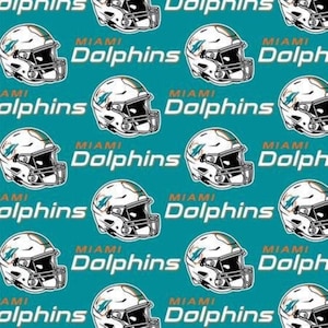 Puede incluir: Un patrón de tela color verde azulado con cascos de fútbol americano blancos de los Miami Dolphins repetidos y el texto Miami Dolphins en letras blancas. El diseño muestra el logo del equipo en el lateral de cada casco con rejilla.