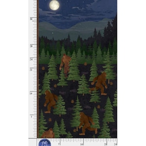 May include: A fabric panel featuring a repeating pattern of brown Bigfoot creatures walking through a dark forest of green pine trees under a full moon and starry night sky, with a vertical ruler showing inches and a horizontal ruler showing inches.