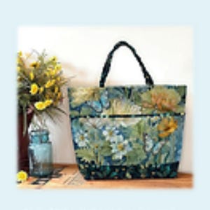 May include: A tote bag with a floral pattern and black handles. The design includes white flowers, butterflies, and green leaves. The text "Playing with Panels Market Tote" is at the top of the image.