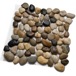 May include: A sheet of natural stone pebble tiles in various shades of brown, beige, and black. The pebbles are arranged in a random pattern and are set on a mesh backing.