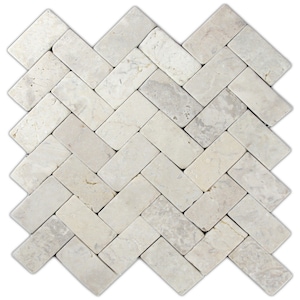 May include: A light beige marble tile arranged in a herringbone pattern. The rectangular tiles have a natural, slightly textured appearance with subtle variations in color, creating a classic and elegant look. Ideal for flooring or wall applications.