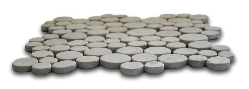 May include: A gray, pebble-like mosaic tile mat. The mat is composed of numerous, irregularly shaped, flat, circular stones. The stones are arranged in a slightly curved pattern, creating a textured surface. The color is a neutral gray, with subtle variations in tone.