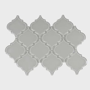 May include: A collection of light gray, arabesque-shaped tiles arranged in a grid pattern. Each tile has a smooth, reflective surface and a distinctive quatrefoil design. The tiles are suitable for various interior design applications.