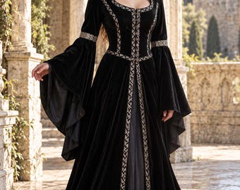 Peut inclure: Une robe longue en velours noir avec de longues manches évasées, un col montant et une encolure carrée. La robe est ornée de broderies argentées complexes le long de l'ouverture avant, des poignets et de la taille, avec une jupe gris foncé.