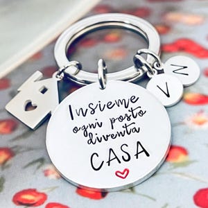 Puede incluir: Una taza de cer&aacute;mica blanca con un asa negra y el texto "But First, Coffee" en negrita negra. La taza se encuentra sobre un fondo borroso, sugiriendo un ambiente acogedor.