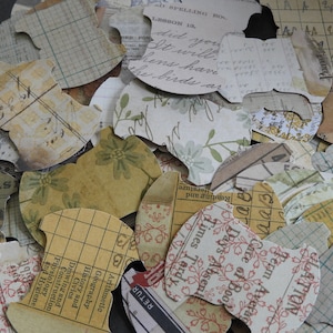 May include: Assortment of vintage paper scraps in various patterns and colors, including floral, grid, and text. The scraps are cut into different shapes and sizes, perfect for scrapbooking, card making, or other craft projects.