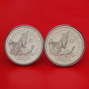 May include: Two silver dollar coins with the inscription "United States of America" and "Treaty with the Delaware 1778". The coins feature a wolf, a turkey, and a turtle.
