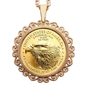 Puede incluir: Un collar con un colgante de oro que presenta una moneda de oro American Eagle de 1/10 onza con una imagen detallada de un águila calva. La moneda está rodeada por un marco decorativo y ornamentado.
