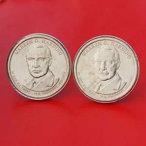 May include: Two silver-colored commemorative coins featuring a portrait of Warren G. Harding, the 29th President of the United States. The coins are inscribed with "Warren G. Harding", "In God We Trust", "29th President", and "1921-1923".