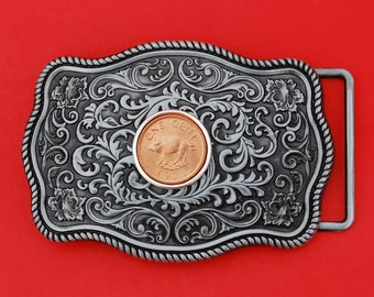 May include: A silver belt buckle with an ornate design featuring a 1971 Canadian one-cent coin with a pig on it.