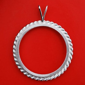 May include: A silver-toned pendant setting with a round, rope-like border and a V-shaped bail.