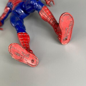 May include: Red and blue Spider-Man action figure with the text "MARVEL TM & &copy; 2006" on the bottom of one foot and "Licensed Made in China" on the bottom of the other foot.